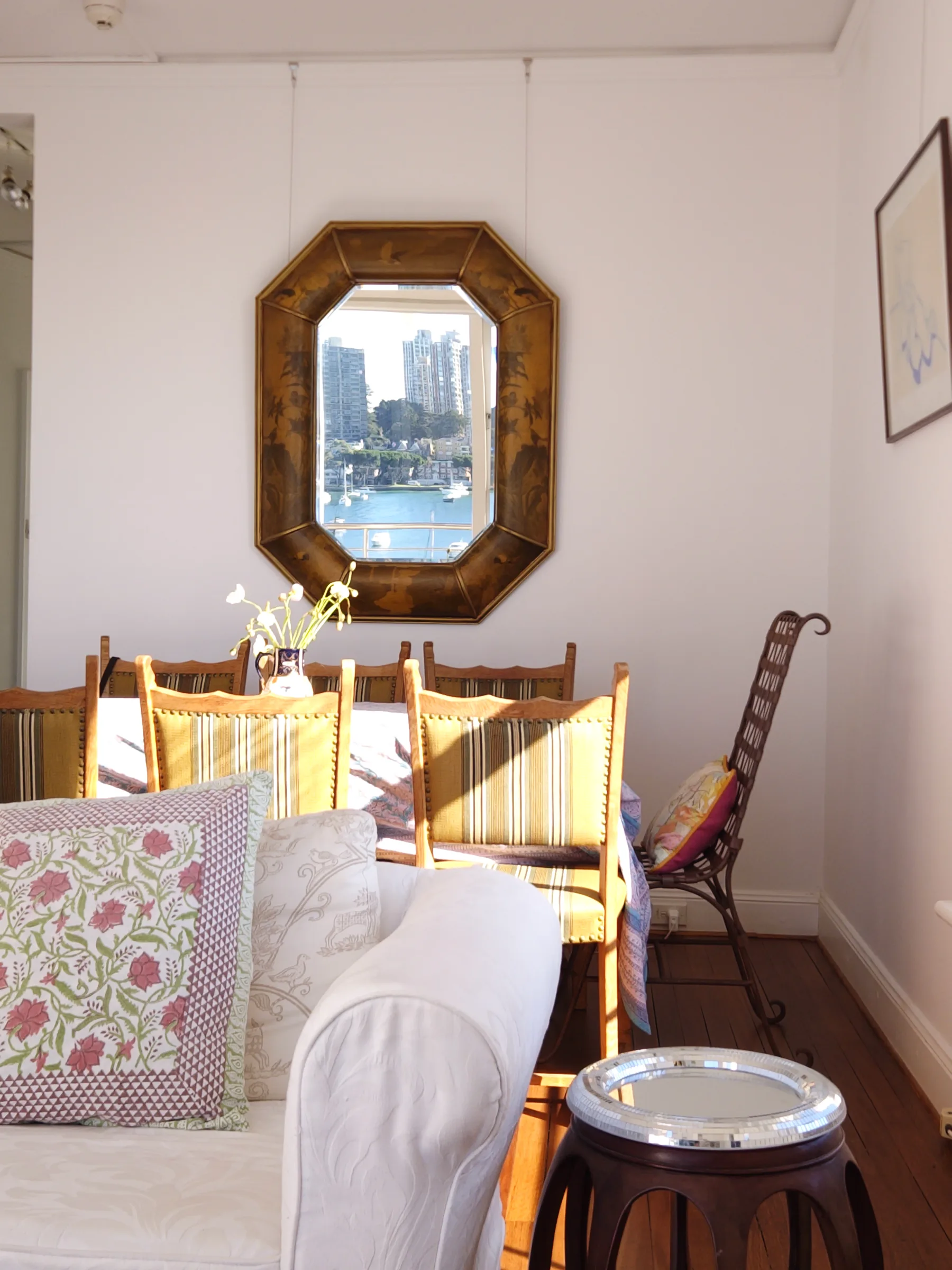 The octagonal chinoiserie mirror and oak dining chairs in the Musetta showroom